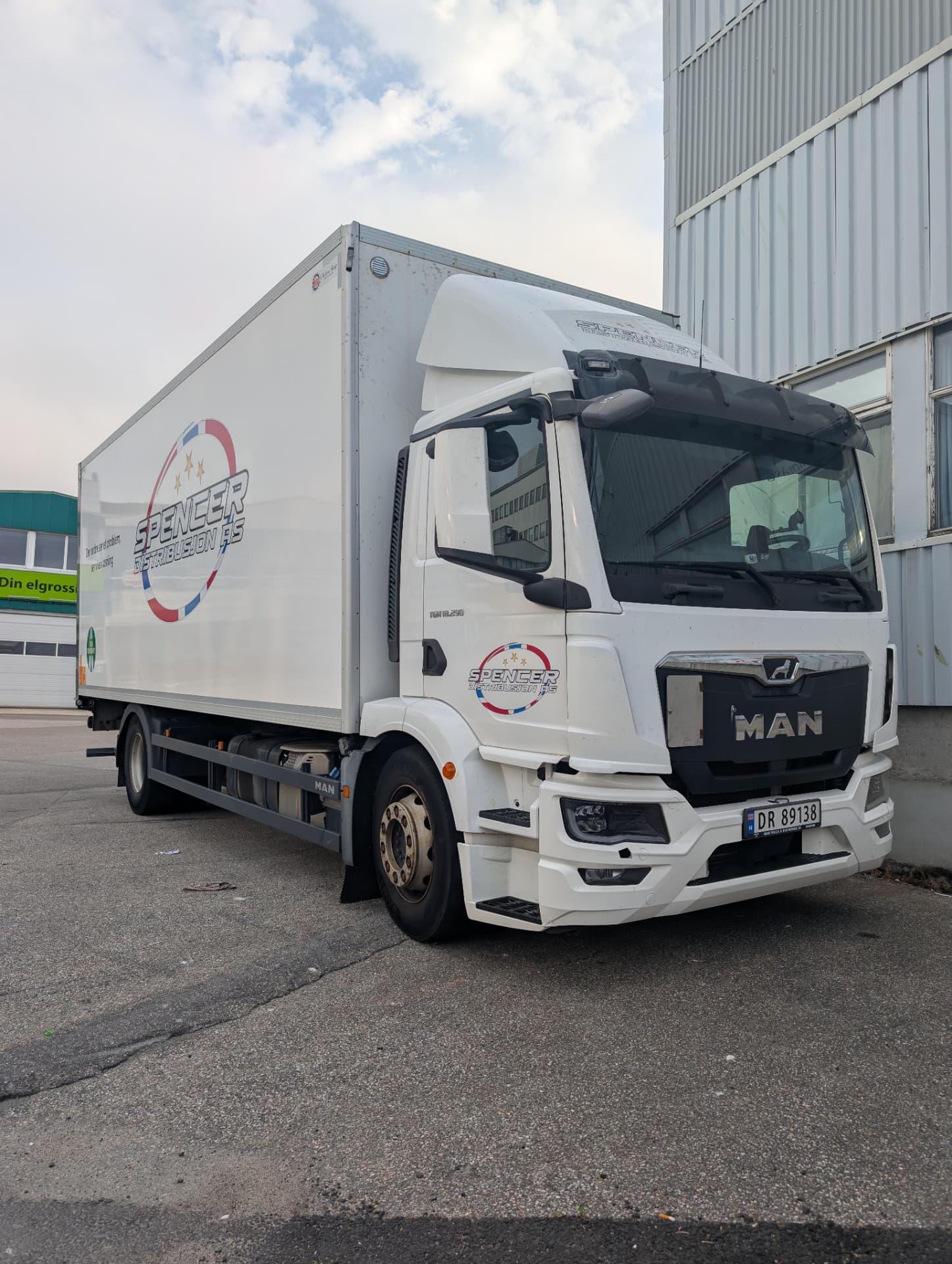 Hvit MAN TGM-lastebil fra Spencer Distribusjon AS parkert ved terminalbygg